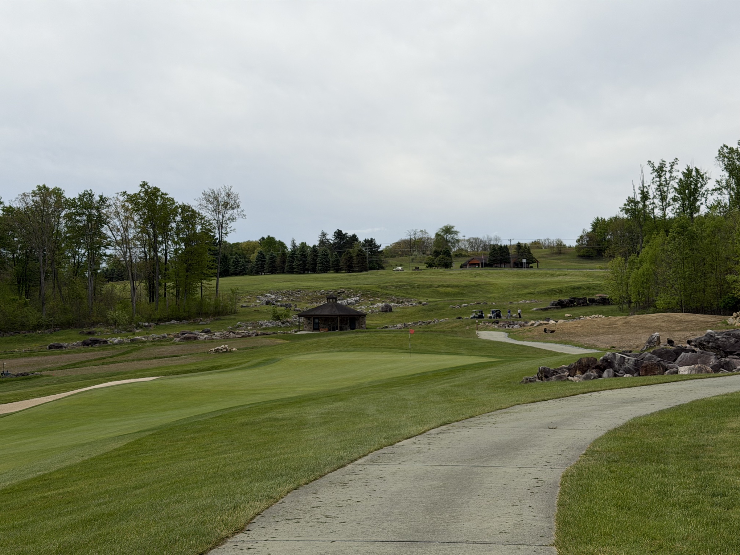 Stacked stone and bedrock framing the green — Mystic Rock holds its ground, literally