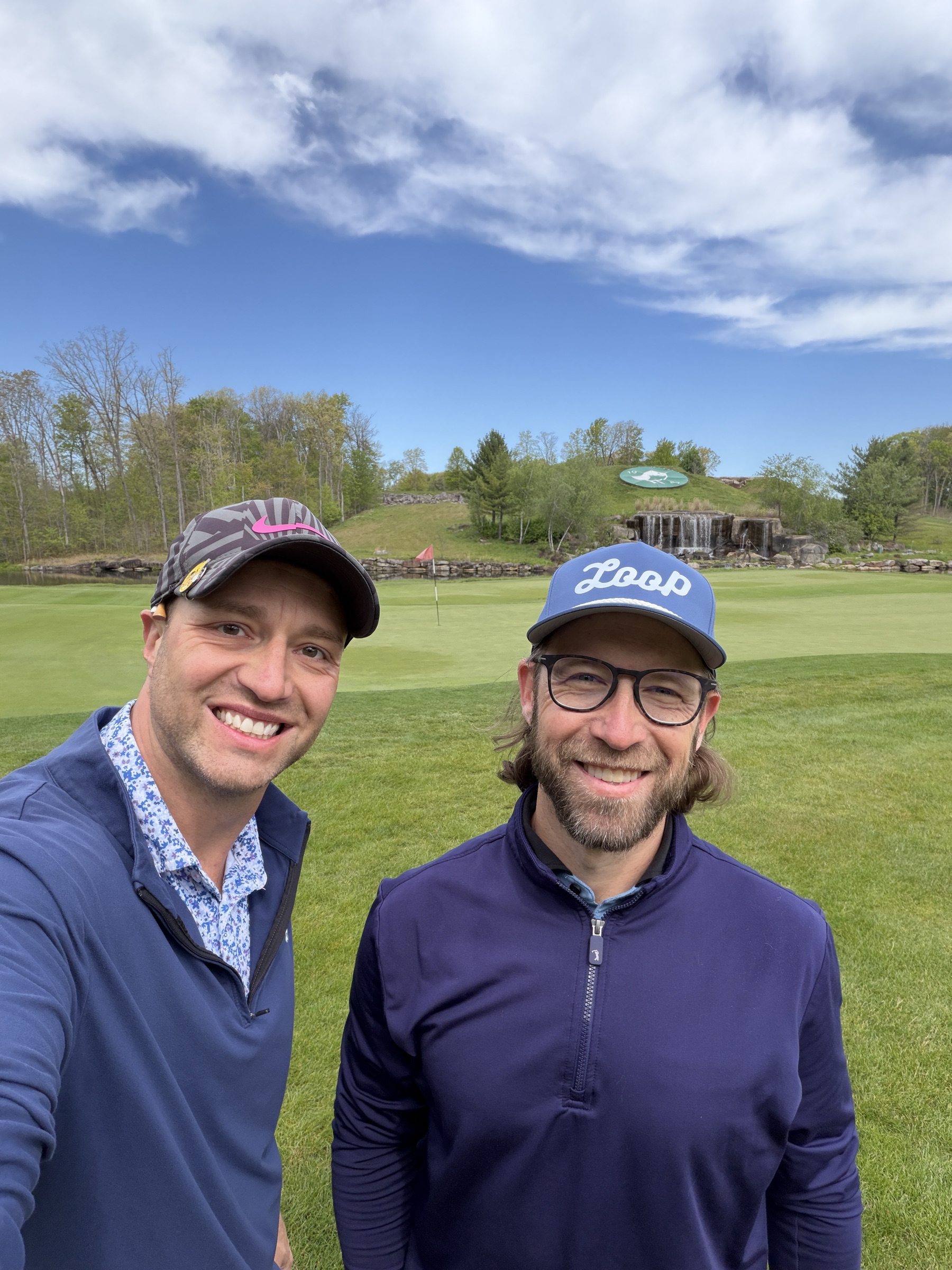 On the green with the stacked-stone bulkhead behind us